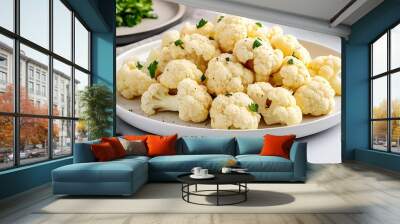 semi close-up of steamed cauliflower florets on a white plate, simple vegan presentation with a sprinkle of sea salt, bright and airy kitchen with natural light, minimalist aesthetic, slightly Wall mural