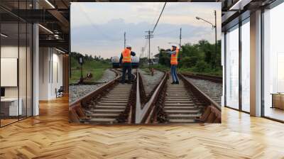 Senior male and female railway engineers are inspecting the railroad tracks for maintenance and improvements to ensure safe transportation of goods. Wall mural