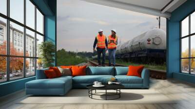 Senior male and female railway engineers are inspecting the railroad tracks for maintenance and improvements to ensure safe transportation of goods. Wall mural