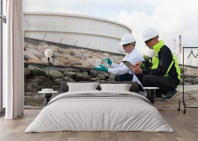 Two specialist  of environmentalist working to collect the water samples and visibly check quality  from the natural sources at the refinery Wall mural