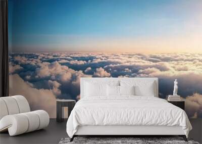 A breathtaking view of blue sky and fluffy clouds illuminated by the golden sunlight, creating a serene and peaceful atmosphere. Wall mural