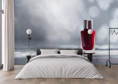 Elegant red nail polish bottle on a smooth surface with a blurred silver bokeh background. Perfect for beauty and cosmetic themes. Wall mural