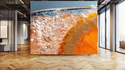 Refreshing beverage with orange slice, bubbles, and colorful background, ideal for summer drinks. Wall mural