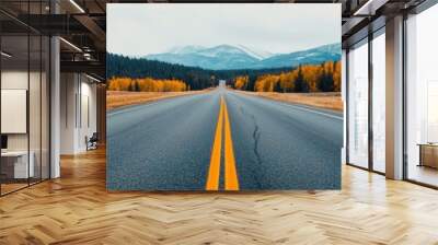 Scenic highway stretching through colorful autumn landscape with mountains in the distance. Wall mural