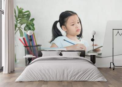 child is serious studying homework during online lesson at home, social distance during quarantine, self-isolation, online education concept, home school, study online video call teacher. Wall mural