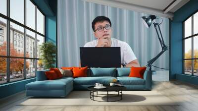 technology, remote job and lifestyle concept - happy asian man  man in glasses with laptop computer working at home office or online shopping, home work, freelance, online learning, studying. Wall mural