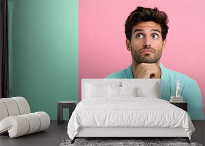 Thoughtful young man pondering against a colorful backdrop Wall mural