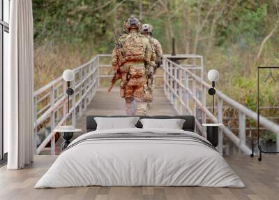 Back of military or soldier team with battle suit walk on the bridge near flare firework during outdoor practice. Wall mural