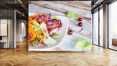 Bowl of vegetable salad on wooden table Wall mural