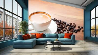 Close-up of a cup of latte with golden foam and mixed or blend coffee beans  on an old wooden floor, top view. Wall mural