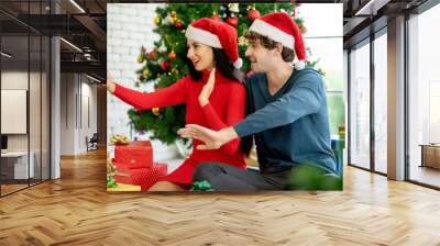 Couple man and woman with Christmas costume use mobile to selfie or online contact with other people. Wall mural