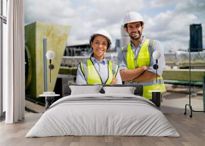 Portrait of two professional engineer or technician workers stand and look at camera with smiling and arm-crossed on terrace of construction site and day light. Wall mural