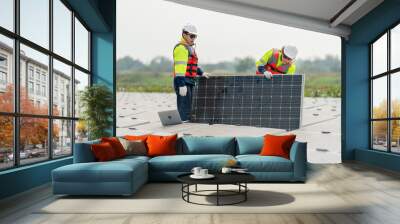 Two professional technician workers stand and hold solar cell panel in area of network of base over area of water reservoir. Wall mural