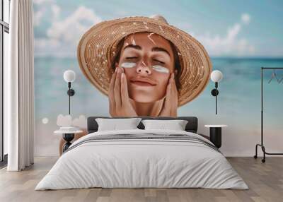 A woman applying sunscreen to her face while standing on a beach Wall mural