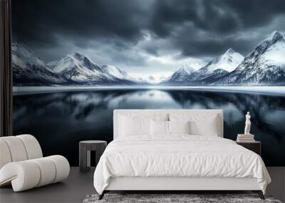 A mountain range is reflected in a body of water. The sky is dark and cloudy, creating a moody atmosphere Wall mural