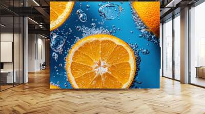 Bright orange slices float in sparkling water, surrounded by ice cubes and bubbles, creating a vibrant and refreshing scene that captures the essence of summertime. Wall mural