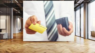 Businessman holding bank card. Wall mural