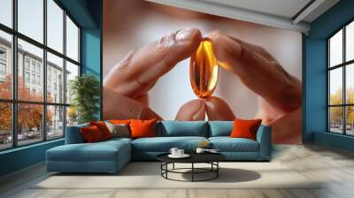 A person's hands hold a yellow pill, symbolizing health, wellness, supplements, medication, and care. Wall mural