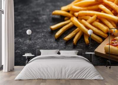 A close-up of a slice of pepperoni pizza and a pile of golden french fries, arranged on a wooden cutting board. The food is displayed on a dark, rustic background, symbolizing comfort, indulgence, and Wall mural