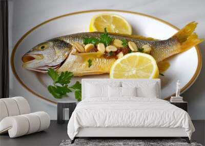 A delicious and healthy meal featuring a whole fish stuffed with almonds and raisins, served on a white plate with lemon wedges and fresh parsley. This dish symbolizes a balanced meal, a commitment to Wall mural