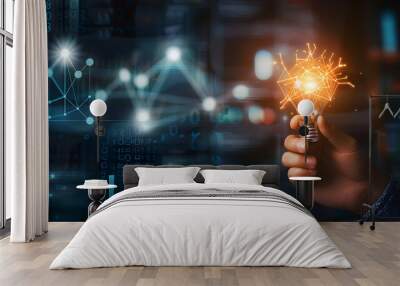 Hand holding a glowing light bulb in front of a business graph It is a symbol of innovation and new ideas. Wall mural