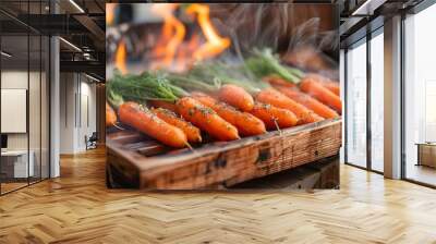 Carrots steaming hot on a wooden tray with a blazing fire close by Wall mural