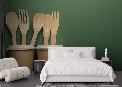 Various items made of recyclable material disposable paper cups and wooden forks on a green background 4K Wall mural