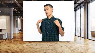 Asian man wearing a green checkered casual shirt posing coolly. Isolated white background. Wall mural