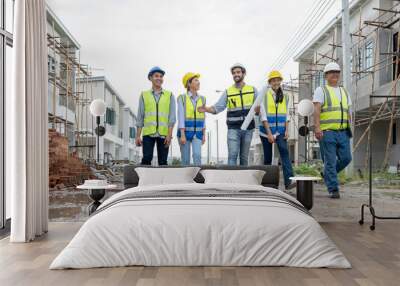 Construction engineer hold house blueprint working with architect, building contractor and foreman at estate site. Project manager meeting discussion with teamwork. Diverse group of people teamwork. Wall mural