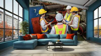 Engineer manager and warehouse workers wear safety helmet working in steel engineering factory. Technician and colleague teamwork in uniform and hardhat standing on production floor for group meeting Wall mural