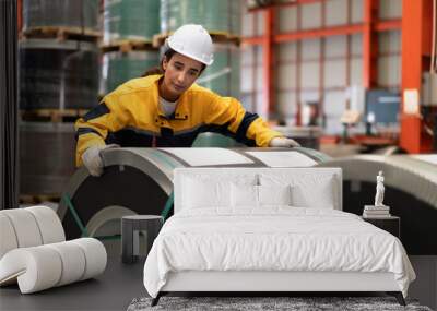 Female industrial engineer in white helmet and safety jacket work in heavy metal engineering factory. Latin inspector woman inspecting production material in metalwork manufacturing facility, portrait Wall mural