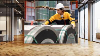 Female industrial engineer in white helmet and safety jacket work in heavy metal engineering factory. Latin inspector woman inspecting production material in metalwork manufacturing facility, portrait Wall mural