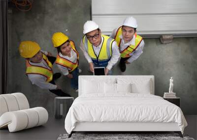 Top view of industrial engineer and factory workers wear safety helmets work in metal engineering industry. Overhead view of teamwork in uniform and hardhat standing on plant floor for group meeting Wall mural