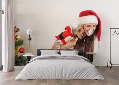 cute funny woman in santa hat with toy terrier near christmas tr Wall mural