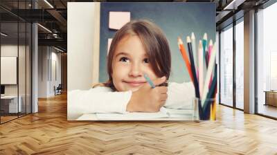 portrait of cute lovely girl drawing in copybook on blackboard b Wall mural