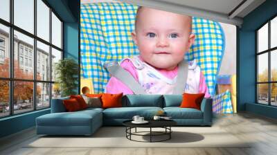 Aborable happy baby girl sitting on the bright baby chair and sm Wall mural