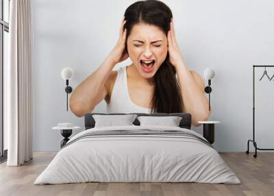 Angry casual woman strong screaming with wild open mouth and covering the ears the hands to not listen news on blue background. Closeup Wall mural