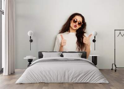 Happy fun positive woman showing two hands ok thumb sign in fashion sunglasses and white t-shirt on white wall background with empty copy space. Happy Wall mural