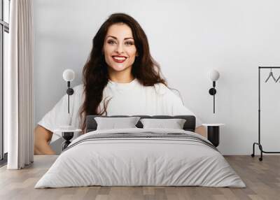 Happy toothy smiling woman posing in blank oversize white t-shirt on blue studio background with empty copy space. Closeup Wall mural