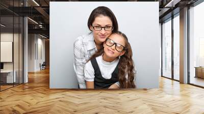 happy young mother and lauging kid in fashion glasses hugging on empty copy space background. family Wall mural