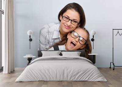 happy young mother and lauging kid in fashion glasses hugging on empty copy space Wall mural