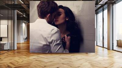 Sexy couple portrait. Man in white shirt kissing his sensual beautiful girlfriend with much emotion in dark drama light with dark shadow. Closeup Wall mural