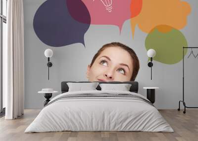 Thinking business woman with idea bulb in bubble on grey Wall mural