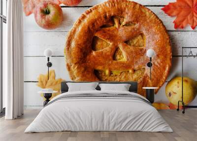 Delicious homemade pie for halloween on white wooden table with apples and fall leaves Wall mural