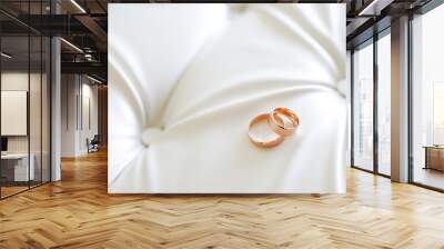 Panoramic banner of two gold wedding rings symbolic of love and romance on a textured leather background with copy space for your greeting or congratulations Wall mural