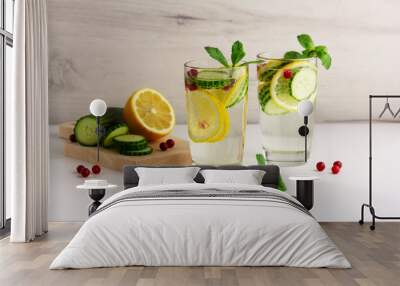 Sassy diet water. Cucumber, lemon, mint lemonade in glasses on light background Wall mural