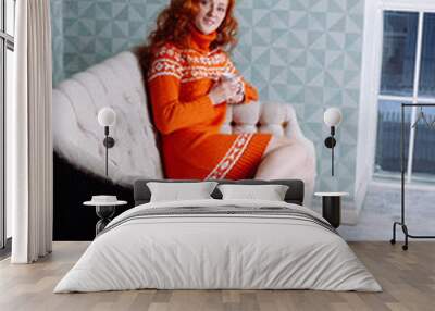 Cozy portrait of  woman in warm sweater on the bed with cup of t Wall mural