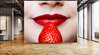 Macro close up of caucasus woman's lips with red lipstick and fresh strawberry. Wall mural