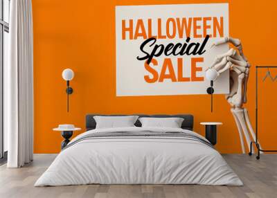 A creative Halloween sale sign held by a skeletal hand, set against a vibrant orange background for festive promotions. Wall mural