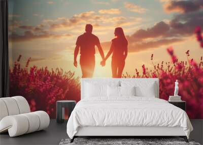 a couple is holding hands in a field of purple flowers. the sun is setting in the background, castin Wall mural